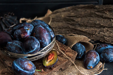 Garden plums on the table. Autumn harvest. Blue plums. Fresh plums on a wooden surface. Fresh plums on a wooden table background. Food Photo