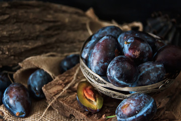 Garden plums on the table. Autumn harvest. Blue plums. Fresh plums on a wooden surface. Fresh plums on a wooden table background. Food Photo