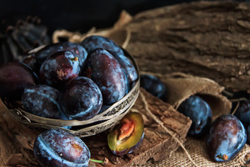 Garden plums on the table. Autumn harvest. Blue plums. Fresh plums on a wooden surface. Fresh plums on a wooden table background. Food Photo