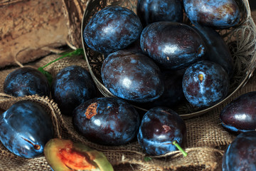 Garden plums on the table. Autumn harvest. Blue plums. Fresh plums on a wooden surface. Fresh plums on a wooden table background. Food Photo