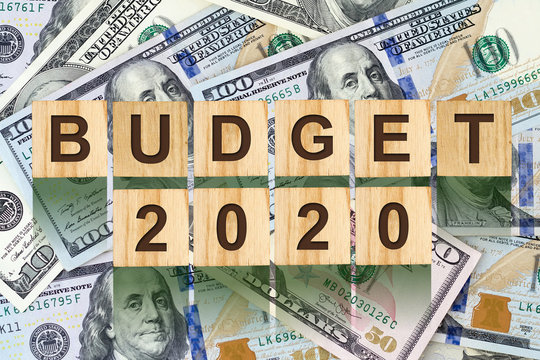 Budget 2020, the inscription on wooden blocks, on the background of dollar bills. New year budget concept. Business.