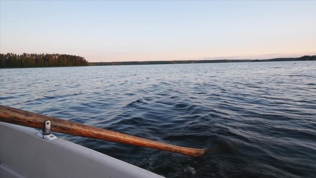 Slow motion shot of a person rowing a rowboat in the middle of summer in northern Sweden.