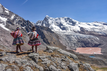 Quechua girls admire Andean mountain views on the Ausungate trail. Cusco, Peru