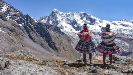 Quechua girls admire Andean mountain views on the Ausungate trail. Cusco, Peru - obrazy, fototapety, plakaty