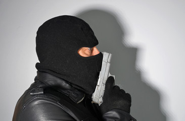 man in mask holding a pistol