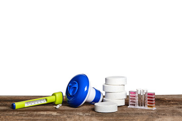 Equipment with chemical cleaning products and tools for the maintenance of the swimming pool on a wooden surface against white background.