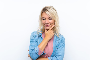 Young blonde woman over isolated white background looking to the side