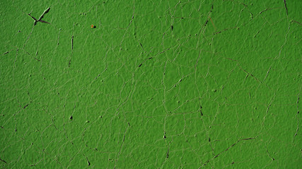  surface of the painted light green metal door with cracks in the paint