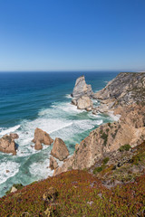 Fototapeta na wymiar Scenic view of the Atlantic Ocean and rugged coastline with huge boulders near Cabo da Roca, the westernmost point of mainland Europe, in Portugal.