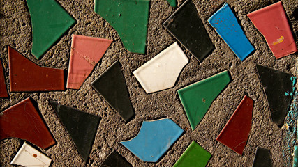 surface of the concrete wall interspersed with colored tiles