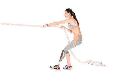 side view of disabled sportswoman training with rope isolated on white