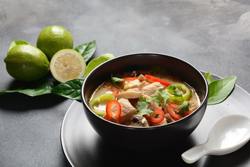 Thai style coconut milk soup-Tom Kha Gai with chicken,mushrooms, galangal, lime leaves, lemongrass, chili peppers. Thai cuisine food concept