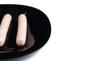 Hot dog with ketchup and mayonnaise on black plate isolated on white background.Breakfast.