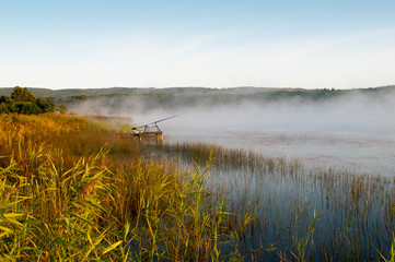 fisherman with fishing rods at sunrise on the lake