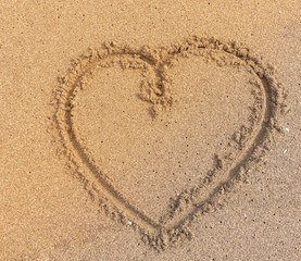 Herz im sand mit warmen Sonnenlicht