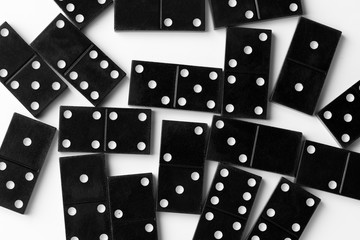 Dominoes top view. Black domino figures. Domino chips close up. Scattered black dominoes.