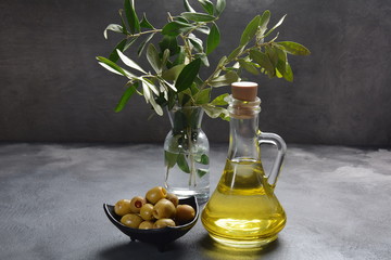 Extra virgin Olive oil , olive branch and olives on a dark background
