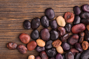 Broad beans. Bean seeds close-up. Dry broad beans of different varieties on a wooden background.