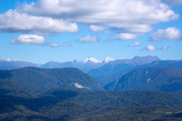 Fototapeta premium Forests and the Caucasus Mountains. Beautiful Caucasian mountains on a background of blue sky and clouds.