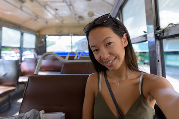Young tourist woman exploring the city of Bangkok with bus