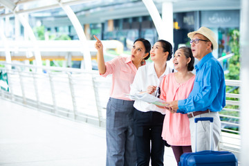 Travel and tourism concept.Group of senior people traveling in the city and looking the map in hand for Shopping Mall Search