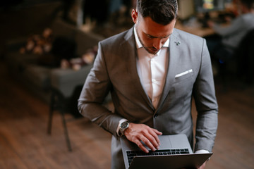 Businessman in grey suit using laptop