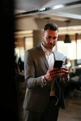 Businessman in grey suit using phone