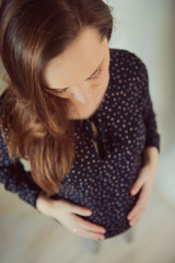 Fototapeta premium Pregnant woman sticks behind belly