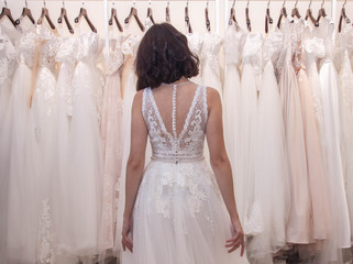 bride chooses wedding dress in wedding dress shop