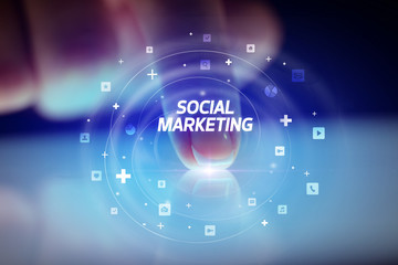 Finger touching tablet with social media icons and SOCIAL MARKETING