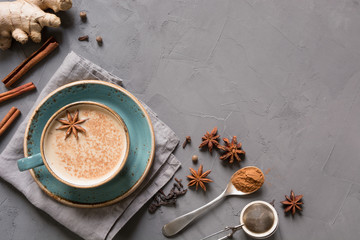 Masala Indian tea in cup with spices on grey concrete table. Top view. - obrazy, fototapety, plakaty