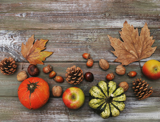 Autumn flat lay background. Pumpkins, apples, nuts,leaves, cups and sweater on wooden background.