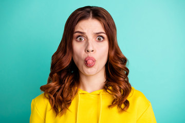 Photo scared afraid curly wavy frightened youngster sticking tongue out with teasing face...