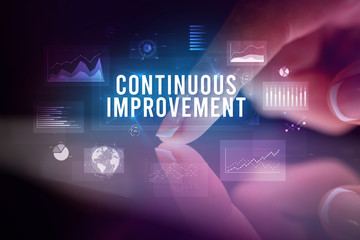 Finger touching tablet with charts and CONTINUOUS IMPROVEMENT inscription, business concept