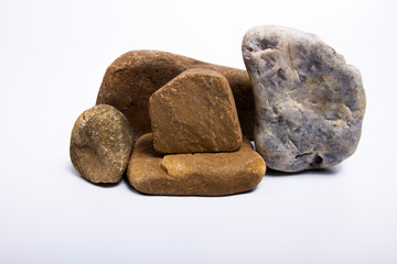 Fototapeta premium Different types of stones are stacked on a separate white background.