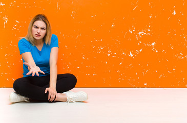 young blonde woman looking angry, annoyed and frustrated screaming wtf or what‚Äôs wrong with...