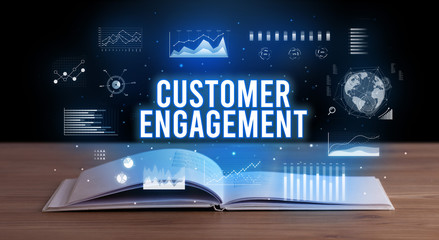 CUSTOMER ENGAGEMENT inscription coming out from an open book, creative business concept