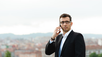 Young successful entrepreneur on business phone call outside in the city.