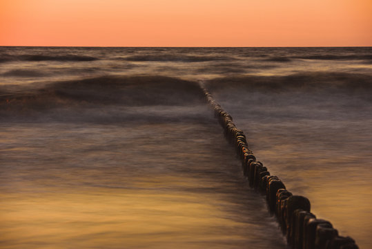 Wooden breakwater at sunset on the Baltic Sea