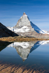 Reflection of Matterhorn peak over Riffelsee in Zermatt, Switzerland in autumn season, sunny day in mountain