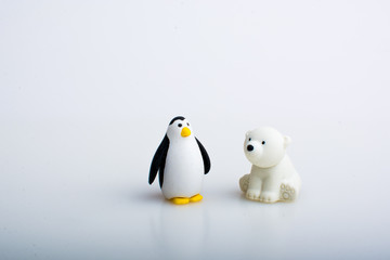 Penguin and polar bear rubber toys, cute animal shaped rubber doll isolated in white background. 