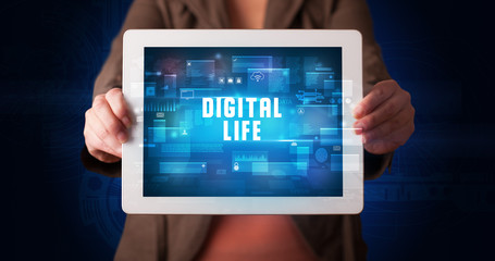 Young business person working on tablet and shows the digital sign: DIGITAL LIFE