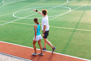 Obraz premium Back view of a healthy fitness couple walking at the stadium
