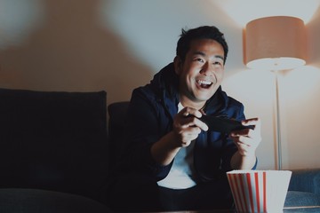 Man sitting on sofa playing game.