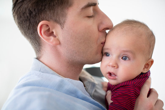 Loving Father Giving 9 Month Old Baby Son A Kiss