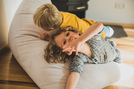 Zwei Kinder raufen im Wohnzimmer