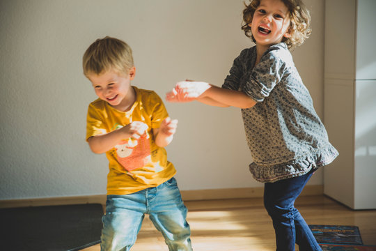 Zwei Kinder raufen im Wohnzimmer