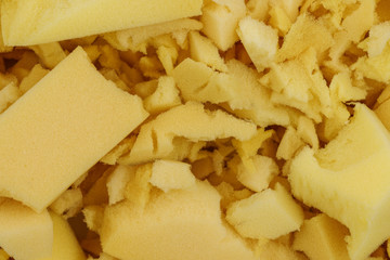 yellow polyurethane foam rubber pieces background texture. stuffing for pillows and furniture