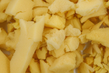 yellow polyurethane foam rubber pieces background texture. stuffing for pillows and furniture