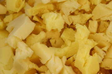 yellow polyurethane foam rubber pieces background texture. stuffing for pillows and furniture